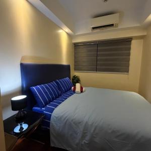 a bedroom with a bed and a blue couch at RKJ condotel 2BR in Cupang +4 photos