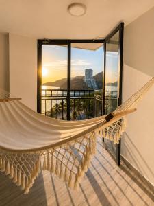 a hammock in a room with a view of the ocean at Apartamento 10c Edf.Playa in Santa Marta +22 photos