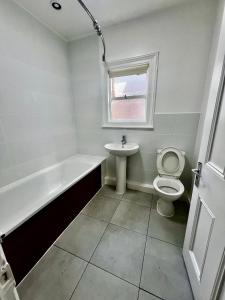a bathroom with a tub and a toilet and a sink at East Croydon Train Station in Croydon