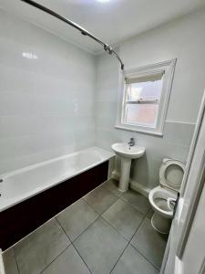 a bathroom with a tub and a toilet and a sink at East Croydon Train Station in Croydon +38 photos