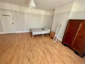 an empty room with a bed and a mirror at East Croydon Train Station in Croydon