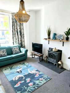 a living room with a blue couch and a fireplace at St Leonards in Hollington