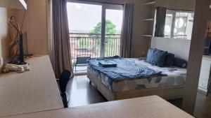 a small room with a bed and a balcony at Studentpark apartment by RD in Yogyakarta +6 photos