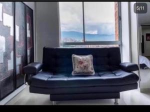 a blue couch in a room with a window at Loft Premium El Poblado in Envigado