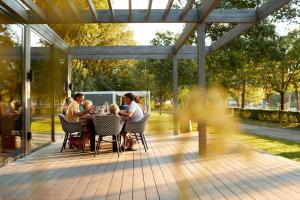 a group of people sitting at a table on a patio at Forest Cube 5 persons #702 in Maasbree