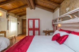 a bedroom with a large bed with red pillows at Valle Dell'Aquila Country House in Settefrati