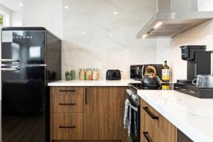 a kitchen with a black refrigerator and wooden cabinets at Spacious 1BR 1bath near DTLA in Los Angeles +2 photos