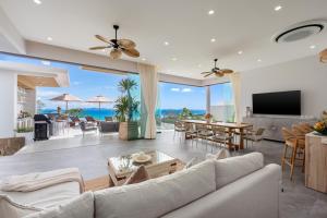 a living room with a couch and a television at Mee Kham Sook Luxury Villa in Nathon Bay