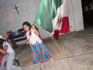 a young girl holding a flag in a room at Quinta Kendriel in Tezoyuca