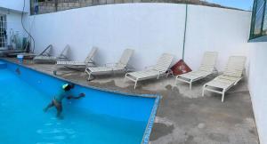 a person playing in a swimming pool with chairs at Quinta Kendriel in Tezoyuca