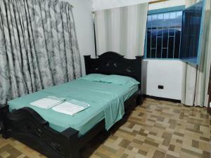 a bedroom with a bed with green sheets and a window at Alojamiento Las Rocas in Confines +5 photos