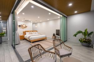 a bedroom with a bed and two chairs at Mee Kham Sook Luxury Villa in Nathon Bay +73 photos