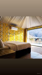 a bedroom with a large bed with a yellow wall at Mirthe rum in Disah