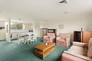 a living room with a couch and a table at Mary MacKillop Spirituality Centre Baulkham Hills in Baulkham Hills