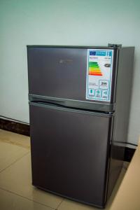 a black refrigerator is sitting in a room at The new home in Moshi