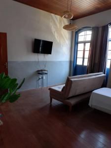a living room with a couch and a tv at Caminhos da Liberdade Pousada in Ouro Preto