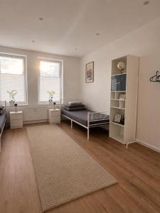 a large room with a bed and two windows at H&R Suite - Bielefeld Central in Bielefeld