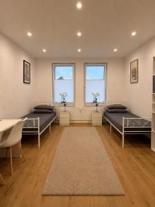 a room with two beds and two windows at H&R Suite - Bielefeld Central in Bielefeld