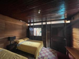 a room with two beds in a wooden room at Hotel bar y restaurante Millenium Lanquin in Lanquín