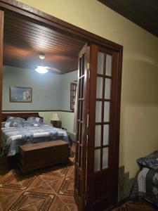 a bedroom with a bed and an open door at Eco Pousada Eldorado Lumiar in Lumiar
