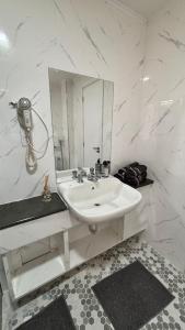 a white bathroom with a sink and a mirror at Palladium Refúgio - 500 metros da Praia, Perto do Shopping, Wi-Fi, Piscina e Garagem in São Vicente +14 photos