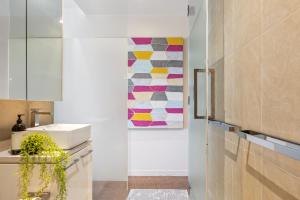 a kitchen with a sink and a painting on the wall at Seaside Studio Apartment in Frankston, Melbourne in Frankston