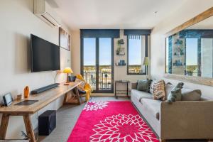 a living room with a couch and a flat screen tv at Seaside Studio Apartment in Frankston, Melbourne in Frankston