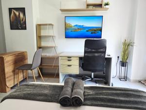 a bedroom with a desk and a bed with a monitor on the wall at The Garden Studio - Spacious Balcony in Lamía