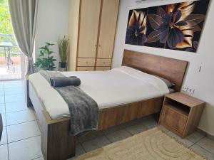 a bedroom with a bed and a painting on the wall at The Garden Studio - Spacious Balcony in Lamía