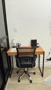 a wooden desk with a chair in a room at Palladium Refúgio - 500 metros da Praia, Perto do Shopping, Wi-Fi, Piscina e Garagem in São Vicente