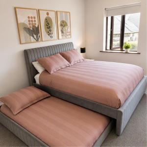 a large bed with a cushionedinylinylinyl bedskirts at Ardee Retreat - Sleeps 6, Garden, Walk to Town in Ardee