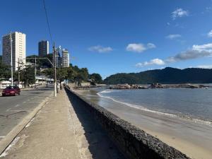 a beach with a retaining wall next to the water at Palladium Refúgio - 500 metros da Praia, Perto do Shopping, Wi-Fi, Piscina e Garagem in São Vicente