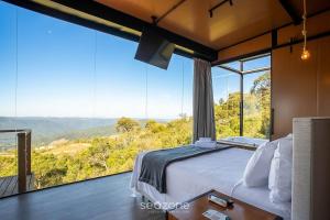 a bedroom with a bed and large glass windows at Charming chalet with fireplace and hot tub! VST045 in Annitapolis