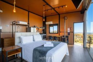 a bedroom with a large bed and a kitchen at Charming chalet with fireplace and hot tub! VST045 in Annitapolis