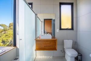 a bathroom with a sink and a toilet and a mirror at Charming chalet with fireplace and hot tub! VST045 in Annitapolis