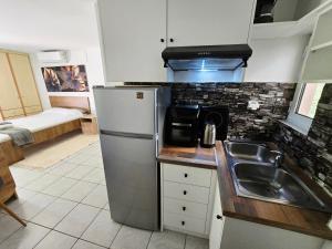 a kitchen with a stainless steel refrigerator and a sink at The Garden Studio - Spacious Balcony in Lamía