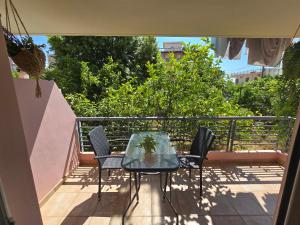 a patio with a table and chairs on a balcony at The Garden Studio - Spacious Balcony in Lamía