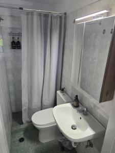 a bathroom with a white toilet and a sink at The Garden Studio - Spacious Balcony in Lamía +3 photos