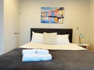 a bedroom with a bed with two towels on it at Sky Stars Essential Reserve in Auckland
