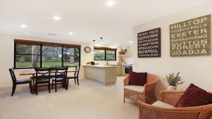 a kitchen and dining room with a table and chairs at Mirambeena in Berrima