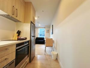 a kitchen with a refrigerator and a table with a chair at Sky Stars Essential Reserve in Auckland