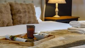 a tray with towels and a candle on a bed at Mirambeena in Berrima