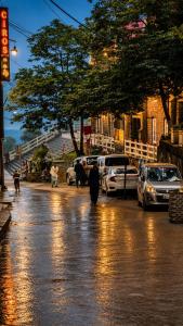 a person walking down a street in the rain at Mall Rd Murree Ciros Hotel in Murree