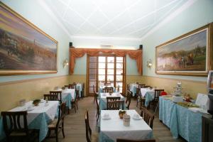 un restaurante con mesas, sillas y pinturas en las paredes en Hotel Desirèe en Florencia