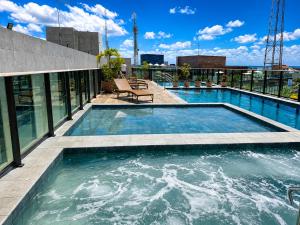 a swimming pool on top of a building at Apartamento com Piscina Rooftop e Hidro perto do Centro e da Praia, Porto Blue Porto de Galinhas in Porto De Galinhas