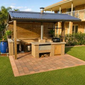 a barbecue grill in the backyard of a house at Seascape Carroll Avenue - close to Mollymook Beach in Mollymook