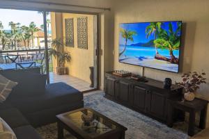 a living room with a couch and a flat screen tv at Princesa de Penasco B208 - Family Beach Getaway in Puerto Peñasco