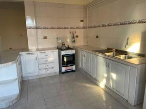 a kitchen with white cabinets and a stove top oven at Maria's Place in Quillacollo