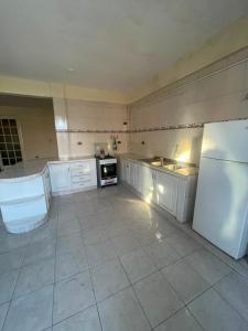 a large kitchen with white cabinets and a refrigerator at Maria's Place in Quillacollo