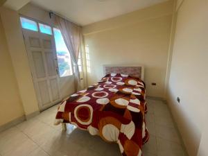 a bedroom with a bed and a window and a door at Maria's Place in Quillacollo